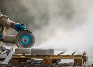 A person cutting concrete with an angle grinder.