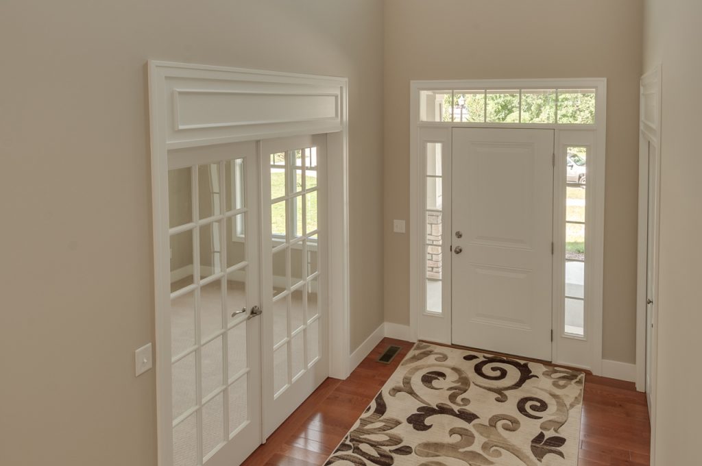 A white door and two windows in a room.