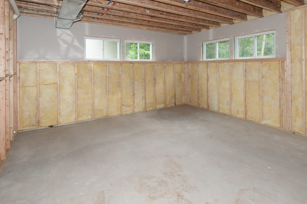 A room with wood paneling and concrete floors.