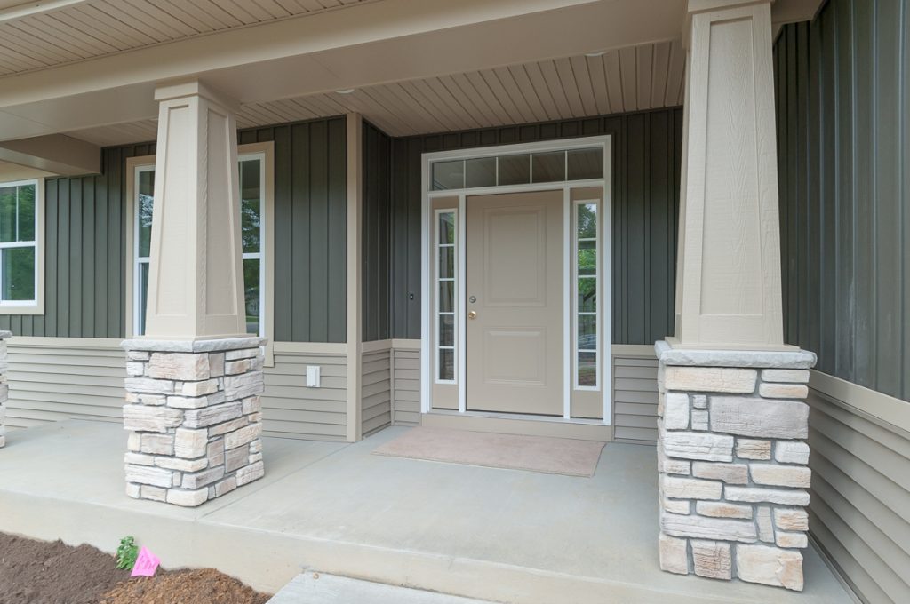 A front porch with two pillars and a door.