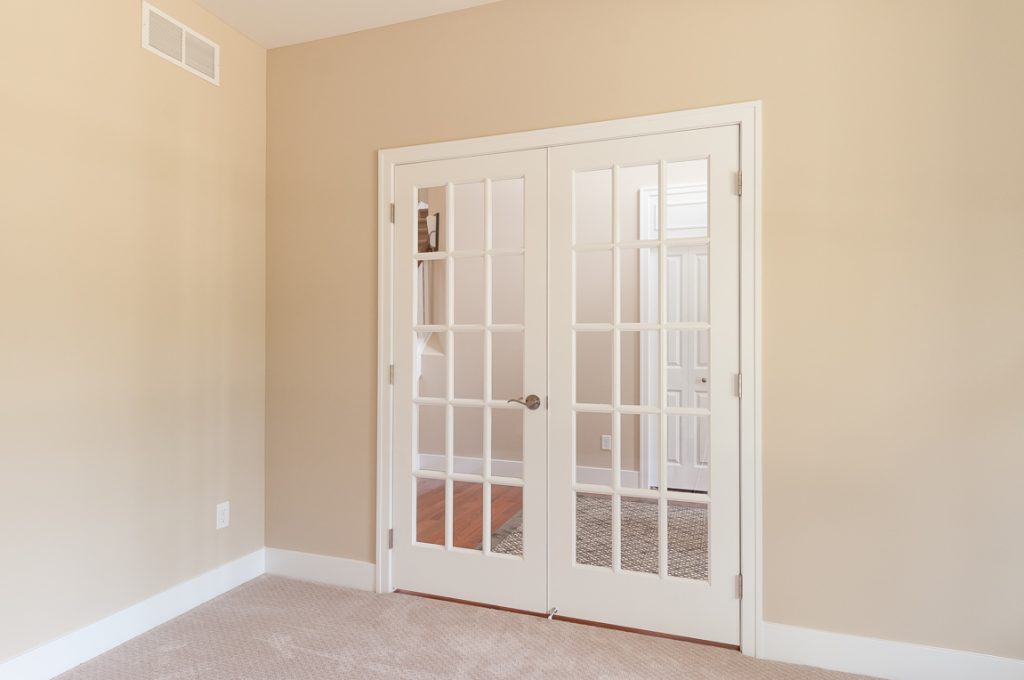 A room with two doors and beige walls