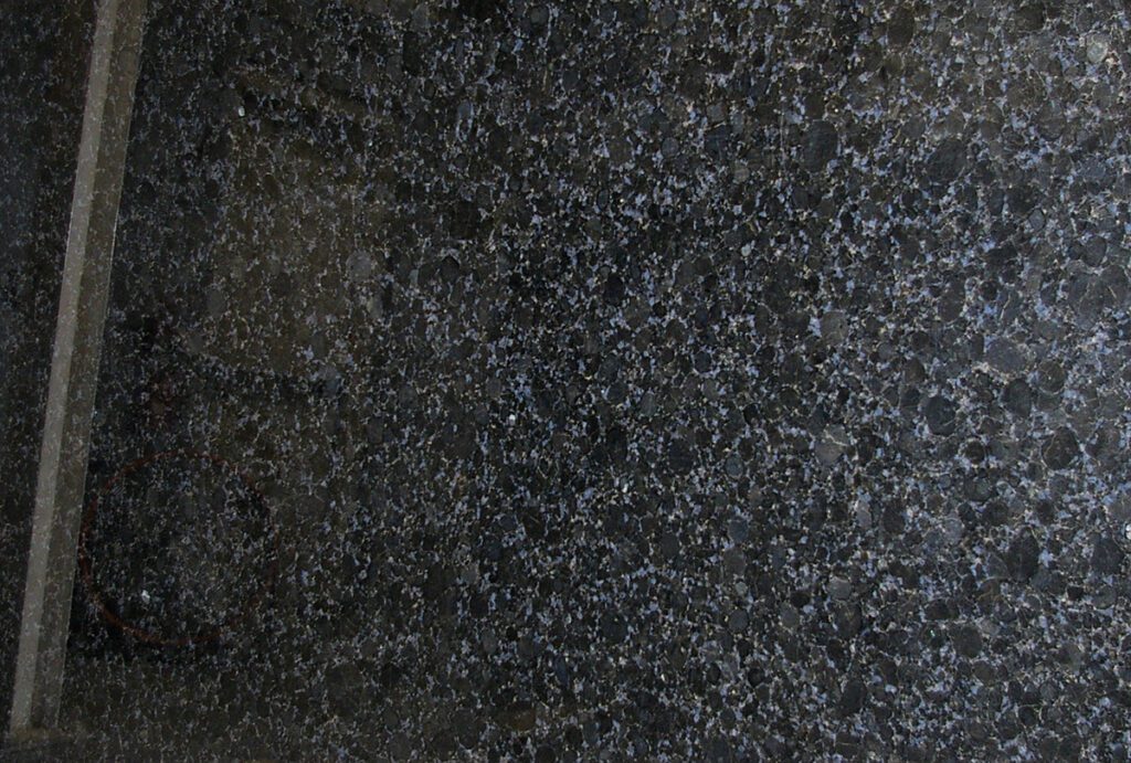 A black granite surface with some small white dots.