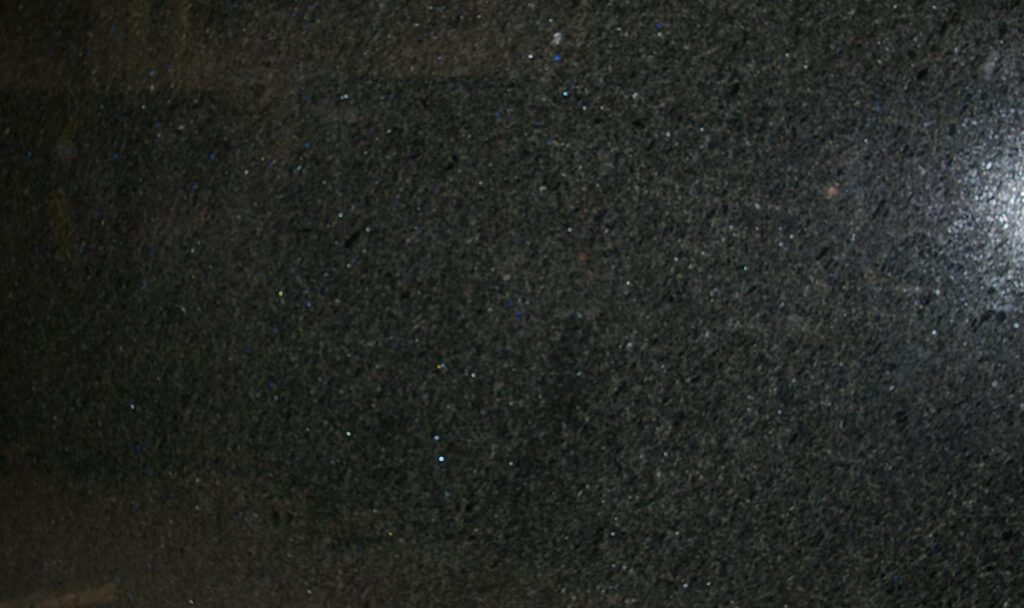 A black granite slab with some white spots on it