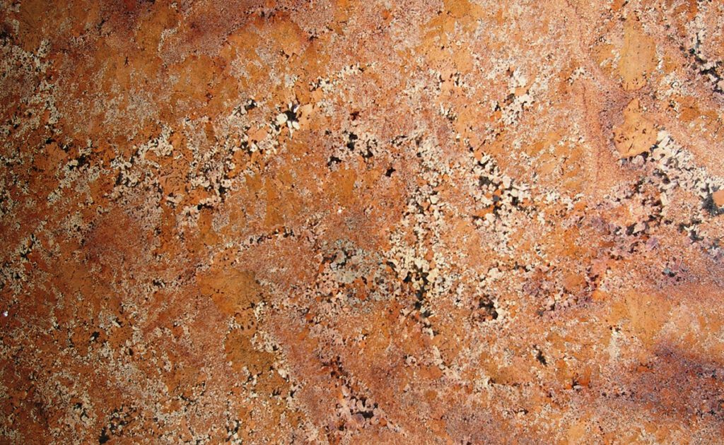 A close up of the surface of an orange granite slab.