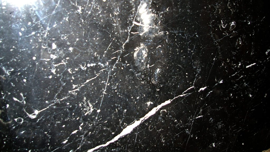 A black marble surface with some white spots