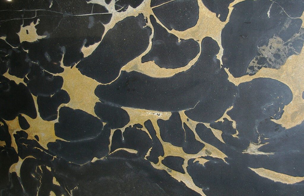 A black and gold marble pattern with some white spots.